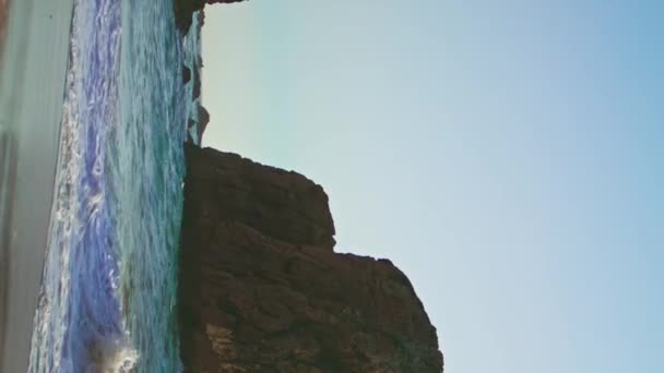 ポルトガルの海面上に上昇する岩の崖ウルサビーチ夏の夜の垂直ショット 高い石の岩の静かなビューは 嵐の海の波の空の海を洗った 美しい海岸線の風景 — ストック動画