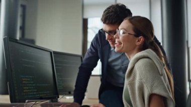 Yöneticiyle yazılım kodlarını tartışırken gülümsüyor. Arkadaş canlısı ekip problem çözümünü birlikte analiz eder. Dost canlısı geliştiriciler verileri kontrol etmekten bahsediyor. Profesyonel erkek mühendis kadın antrenör..