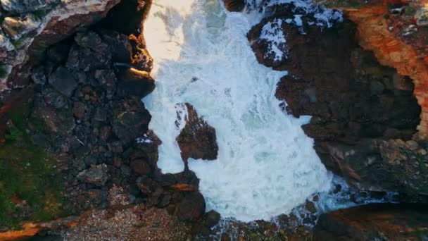 火山の海岸に衝突する強力な嵐の海の波 ロッキーな夏の海岸でスローモーションで洗い流す泡立った白海水 危険な発泡サーフィンとのラフ崖 — ストック動画