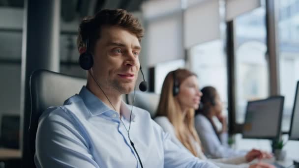 微笑的男人在电话销售中心工作 好客的经理用耳机询问客户 专业的支持代理助理会说打字键盘帮助客户 热线对话概念 — 图库视频影像