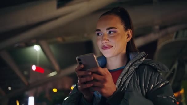 Счастливая Девушка Обменивающаяся Сообщениями Смартфоном Стоящая Снаружи Ночным Городским Освещением — стоковое видео
