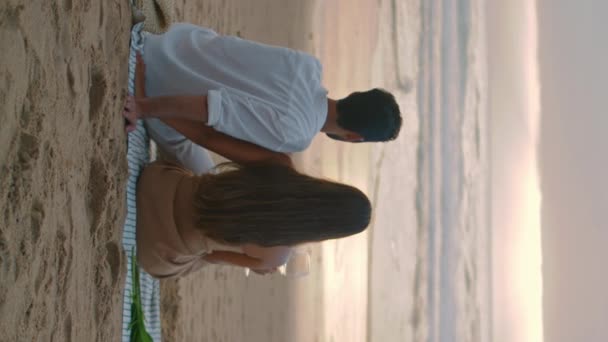 温馨的家人在暑假观望海平线 难以辨认的人在海滨享受日落 后视镜情侣在海滩粘合在一起 伙伴们休息在平静的水景垂直视频 — 图库视频影像
