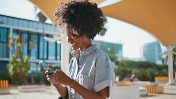 Gelukkige Tiener Kijken Naar Sociale Media Smartphone Lopen Zonnige Straat — Stockvideo