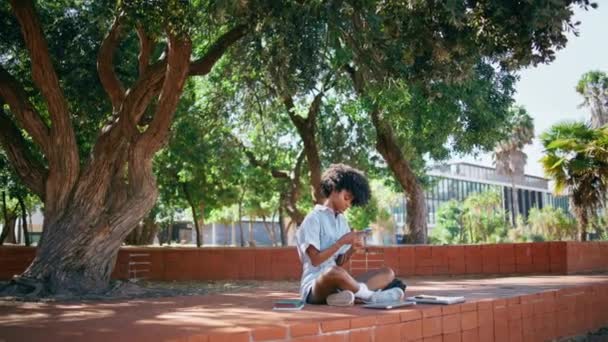 Χαλαρός Έφηβος Κορίτσι Κύλιση Κινητό Τηλέφωνο Κάθεται Στη Σκιά Δέντρο — Αρχείο Βίντεο