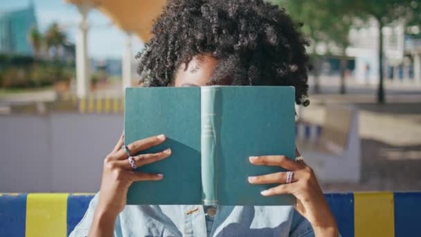 Νεαρό Κορίτσι Κρυφοκοιτάζει Από Βιβλίο Κάθεται Στο Ηλιόλουστο Δρόμο Closeup — Αρχείο Βίντεο