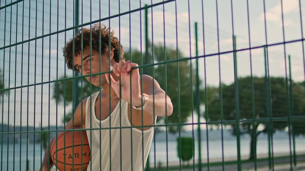 有重点的运动员单独持球特写 卷曲的年轻人打篮球 健康的家伙在操场上练习肖像画 严重的青少年在训练后看着相机 夏季生活方式 — 图库照片