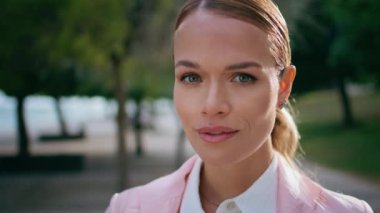 Güneşli şehir caddesinde kameralı şık bir bayan var. Yeşil Park 'ta yalnız poz veren kendine güvenen güzel bir iş kadınının portresi. Şık takım elbiseli mutlu iş kadını dışarıda gülümsüyor..