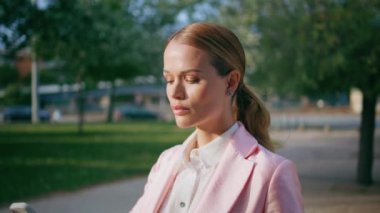 Güneşli caddede bekleyen akıllı iş kadını çağrıya cevap veriyor. Kendine güvenen çekici bir iş kadını akıllı telefonla konuşuyor. Açık havada cep telefonuyla konuşan zarif, ciddi bir kadın..