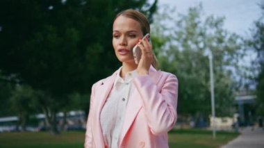 Sakin iş kadını cep telefonunu arıyor. Yeşil Park 'a yaklaş. Akıllı telefonda konuşan çekici, zarif bir bayan gezintide dinleniyor. Açık havada cep telefonuyla başarılı bir yönetici danışmanlığı.