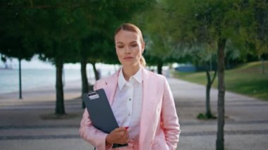 Başarılı bir iş kadını yeşil ağaçların olduğu caddede dikiliyor. Formalite giysisi içinde güzel, kendine güvenen bayan patronun portresi. Zarif kadın CEO gülümseyen bir kamera.