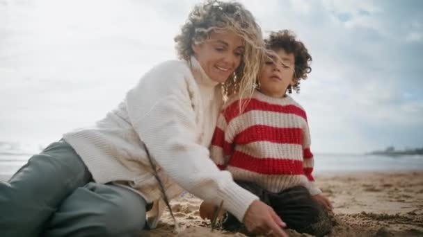 Kudrnatý Maminka Dítě Staví Písek Postavy Pláži Oceánu Šťastný Rodinný — Stock video