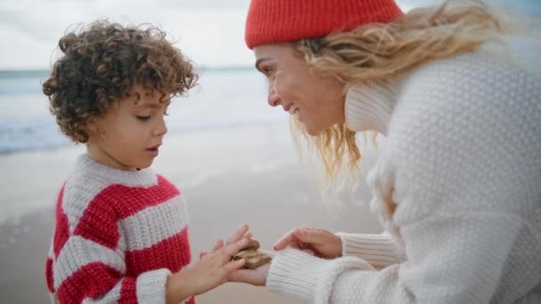 바닷가에서 아이를 가르치고 밖에서 스웨터를 귀여운 아름다운 베이비 시터는아이와 창의적 — 비디오