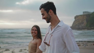 Carefree lovers walking on sandy beach closeup. Smiling girl relaxing with positive guy on beautiful summer nature. Affectionate couple looking each other enjoying tender moment together on seacoast clipart