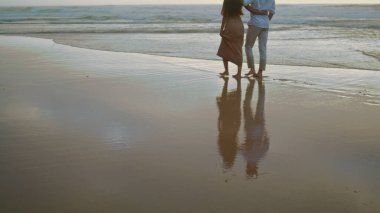 Couple legs crossing ocean at summer closeup. Affectionate married people enjoying seashore. Positive newlyweds spending honeymoon together. Embracing lovers rest at foggy coast. Vacation concept 