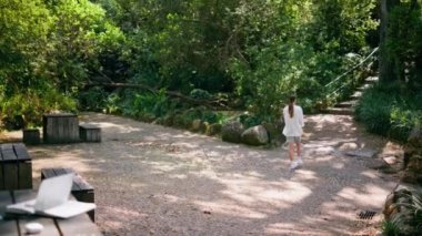 Rahatlamış bir kadın yaz tatilinde Yeşil Park 'ın arkasında geziniyor. Güneşli bir haftasonu yeşillik arasında merdivenlere yürüyen kaygısız genç bir turist. Meçhul bayan dinleniyor, güzel yeşil ormanın tadını çıkarın..