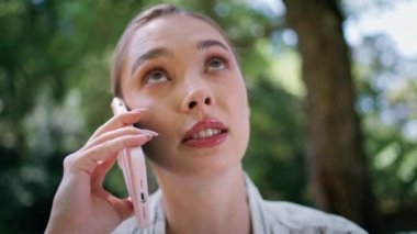 Doğa parkında duran tatminsiz telefon görüşmesinin portresi. Akıllı telefondan konuşan çekici genç bir kadın bahçede kendini rahatsız hissediyor. Göz kamaştırıcı iş kadını cep telefonu konuşmasında yakınıyor.