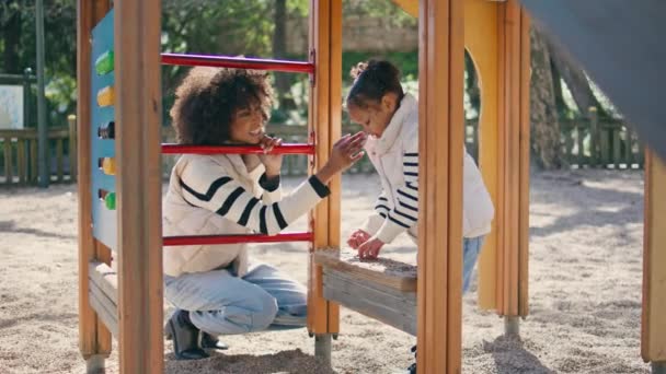 Жінка Дивиться Гру Дочки Стоїть Сонячному Ігровому Майданчику Весела Афроамериканська — стокове відео