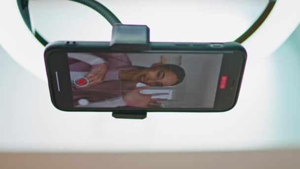 チュートリアルスマートフォンの表示ビューを記録するクローズアップメディアの人 自宅の垂直ビデオで携帯電話放送ビデオブログで話している笑顔の女性 インフルエンサー少女ストリーミング化粧品マスタークラス — ストック動画