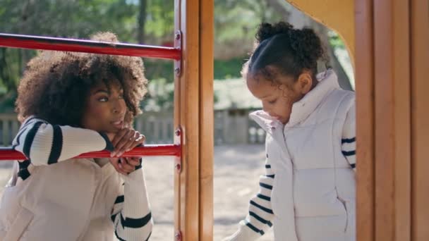 Mamá Viendo Hija Jugando Soleado Parque Infantil Cerca Sonriente Mujer — Vídeo de stock