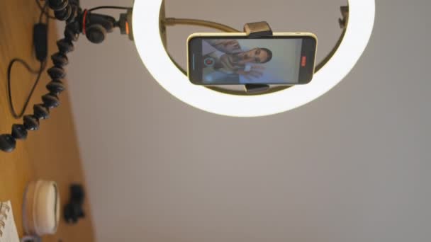 スタジオで化粧品を垂直にクローズアップしたVloggerハンド 美しいブロガーは 部屋で液体を除去する訪問を示しています 毎日セルフケアルーチンを撮影するインフルエンサー女性 電話カメラでチュートリアル — ストック動画