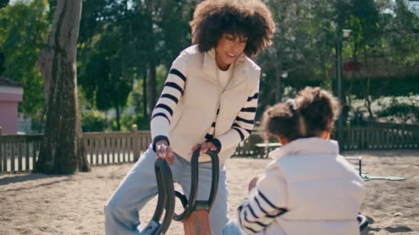 Girl Spinning Carousel Smiling Mother Modern Playground Close African American — Stock Video