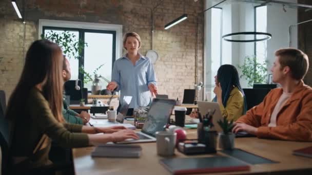 ボードルームの多様なオフィスワーカーに戦略を説明するプロのビジネスコンサルタント スマートな女性は会議室で朝の会議で話す 女性ボスにコーヒーを持参する若いアシスタント — ストック動画