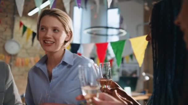 オフィスで企業の勝利を祝うガラスを試すビジネスチームは カラフルなガーランドを装飾しました スパークリングワインを持っている同僚と話す笑顔の女性 うまくいけば 同僚は会社のパーティーを楽しむ — ストック動画