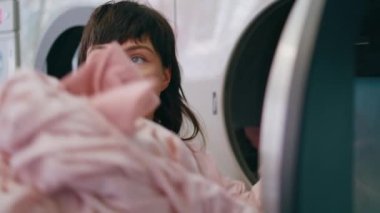 Kadın, davulun yakın çekiminden renkli çamaşırları alıyor. Çamaşırhanede kırmızı çorap tutan kafası karışmış bir kadın. Günlük ev işleri yapan, hayal kırıklığına uğramış gülümseyen bir kadın. Komik durum problemi