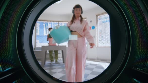 가까운 여자는 기계에 세탁을 이어폰에 음악을 세탁소를 힙스터 바구니 드럼과 — 비디오