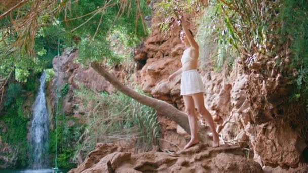 宁静模型在丛林中踏出悬崖火山岩 性感的女人俯瞰着天堂青翠的湖水自然 布鲁内特梦游女孩在异国情调的地方度假 — 图库视频影像