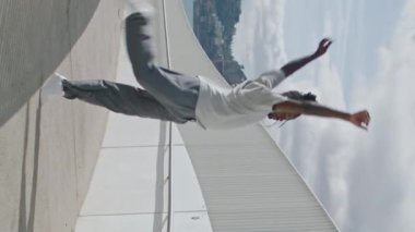 Şehirde tek başına dans eden adam dikey çekim yapıyor. Kahverengi tenli sanatçı tek başına hareket eden bacaklar metal köprü. Sportif Afro-Amerikan dansçı dinamik dansı icat ediyor. Alt kültür yaşam tarzı kavramı