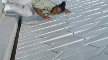 Sanatçının tek başına dans ettiği stadyum dikey çekim. Modern bölgedeki beton duvarlara dokunan kahverengi deri dansçısı. Afrika kökenli Amerikalı profesyonel şehirde çağdaş teknikler gösteriyor