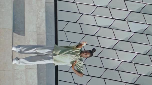 スタイリッシュなパフォーマーのブレイクダンス階段の垂直方向 地下のフリースタイルを実行する熱狂的な男 アフリカ系アメリカ人のダンサーが都市の壁の背景で動く 現代的なライフスタイル — ストック動画