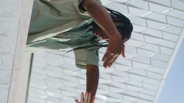 スタジアムの垂直方向でパフォーマンスリハーサルを行うインスピレーションを受けたダンサー 官能的な男性トレーニング軽蔑ダンスはクローズアップを移動します 都市の抽象的な場所でフリースタイルを実践する芸術的なアフリカ系アメリカ人男性 — ストック動画