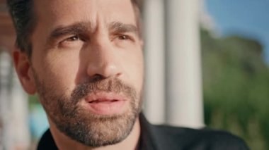 Düşünceli adam, Sunshine Square 'e yakın mesafeden bakıyor. Latin yetişkin sanatçı yaz parkında ilham perisini bekliyor. Güneş ışınlarının önünde duran yakışıklı, traşsız adam. İnsan yaşam tarzı