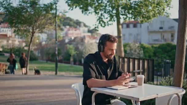 클로즈업에서 스마트 편안한 Melomaniac 레크리에이션 지역에서 전화를 잘생긴 스페인 관광객 — 비디오