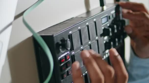 男子双手使用控制台键盘垂直特写 无法辨认的非洲裔美国声音制作人在浅色公寓里混音 未知的褐色皮肤Dj按下按钮创作当代音乐 — 图库视频影像