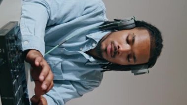 Yaratıcı adam konsolu dikey olarak kapatıyor. Kayıt stüdyosunda siyah saç ses mühendisi karışık şarkı yapıyor. Afro-Amerikan müzik yapımcısı DJ ekipmanlarını dizüstü bilgisayar izlemek için kullanıyor. Meslek ve hobi kavramı