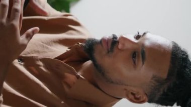 Hareketli iş adamı bilgisayarı dikey olarak arıyor. Kendine güvenen Afro-Amerikalı adam görüntülü sohbette sadece bilgisayarla konuşuyor. Dost canlısı serbest çalışan aile içi iş yerinde online konferans düzenliyor.