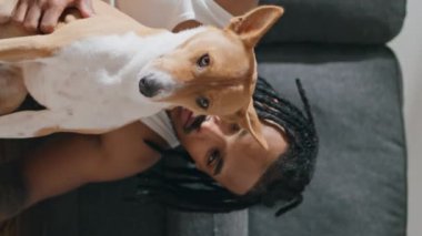 Mutlu adam evde dikey olarak köpeğini okşuyor. Dehşet saçan adam şık bir dairede evcil hayvanı kucaklıyor. Afrikalı Amerikalı ev sahibi oturma odasında köpek arkadaşına sataşıyor.