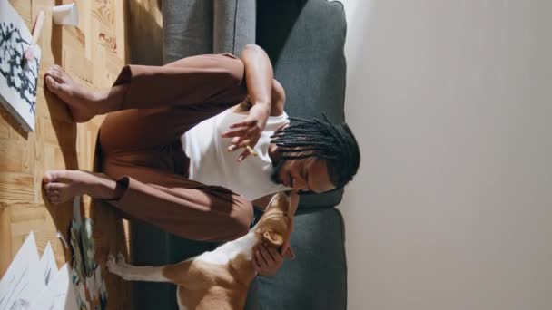 Θετικός Καλλιτέχνης Χαϊδεύει Σκυλί Στον Καναπέ Δωμάτιο Κάθετα Αφρο Αμερικάνος — Αρχείο Βίντεο