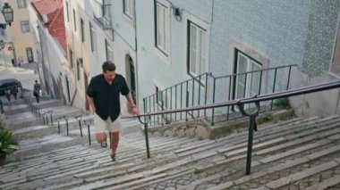 Gezgin yaz gezisinde sokak merdivenlerinde yürür. Yakışıklı adam tek başına Akdeniz otantik evlerini geziyor. Odaklanmış İspanyol turist eski Portekiz şehrinde geziniyor. Seyahat hafızası kavramı 