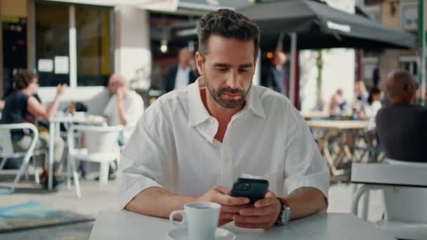 Расслабленный Человек Печатающий Сообщения Смартфоне Уличном Кафе Бородатый Бизнесмен Держит — стоковое видео