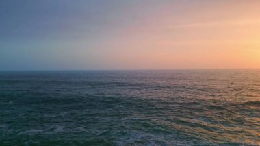 Alacakaranlık manzaralı güzel sakin deniz manzarası. Akşamüstü bulutlu gökyüzünün altında süper yavaş çekimde dalgalanan derin karanlık okyanus. Gün batımında dalgalanan deniz dalgaları. Sakinlik sükunet konsepti.