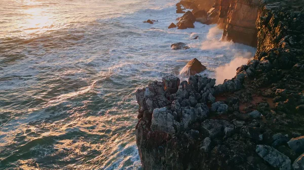 在岩石海岸上的海洋落日被汹涌的水花冲刷得非常缓慢 空中的景色像泡沫一样强烈的海浪冲击着岩石海岸的悬崖 金色的黄昏阳光反射在水中 — 图库照片