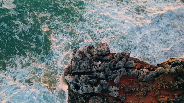 泡沫汹涌的海水在火山岩海岸上冒出气泡 动作非常缓慢 惊人的海浪冲刷在海岸悬崖上 空中风景汹涌汹涌 在岩石海岸下颠簸起伏 — 图库照片