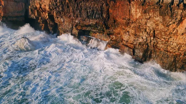 发泡的海浪从空中拍打着岩石海岸 令人叹为观止的危险海水冲撞高山悬崖超级慢动作 浪花冲刷海岸线 — 图库照片