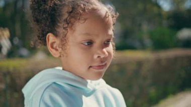 Sevimli Afro-Amerikan çocuk portresi Sunny Park 'ta bilinmeyen bir anneyle duruyor. Beyaz kapüşonlu kapüşonlu küçük şirin kız doğanın üzerinde duruyor. Tatlı mutlu çocuk, yaz tatilinde annesiyle rahatla.