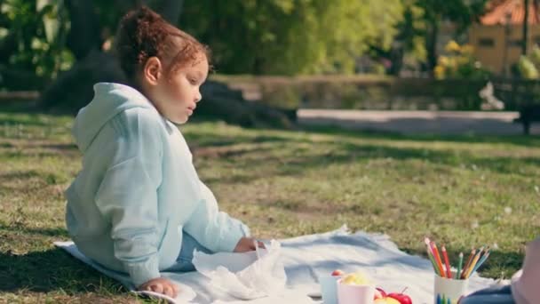 Afrikanskt Amerikanskt Barn Sitter Picknick Vackra Gröna Gräsmattan Nära Okänd — Stockvideo