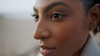 Closeup pensive woman face in blurred background. Beautiful african american model turning head contemplate personal life problems outdoors. Calm attractive girl enjoy solitude take break on weekend